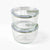 Two clear glass containers with lids stacked on a white background