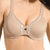 A close-up of a woman wearing a beige wireless bra with decorative white lace trim along the neckline and center gore.