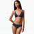 A woman modeling a two-piece bikini set in a dark navy blue color, consisting of a triangle bra top and matching high-waisted briefs, against a plain white background.