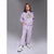 A young girl modeling a light purple/lavender Pusheen sweatshirt and matching sweatpants set, standing against a neutral gray studio background.