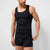 A man wearing a black ribbed tank top and black boxer briefs with a white Nike swoosh pattern, shown against a light gray studio background.