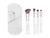 A set of four makeup brushes with white handles and rose gold ferrules, displayed alongside a white carrying case.
