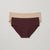 Two pairs of ribbed cotton briefs, one in deep burgundy and one in light beige, displayed flat against a light gray background.