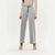 A model wearing light gray wide-leg denim jeans, a beige long-sleeve top, and white strappy high-heeled sandals, shown from the waist down against a plain white studio background.