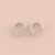 Silver hoop earrings with small stones on a beige background