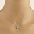 A silver chain necklace with a small butterfly pendant set with clear stones, displayed on a beige mannequin neck.