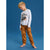 A young boy wearing a two-piece pajama set consisting of a light gray long-sleeve shirt with a monster truck graphic and orange patterned pants, standing against a solid blue studio background.