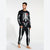 A man modeling a black long-sleeve pajama top and matching pants set with a white skeleton print. The top features a white rib cage graphic with a small red rose at the center chest, and the pants have white bone graphics down the legs.