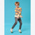 A young boy wearing a colorful striped knit sweater, dark gray jeans, and white sneakers with green accents, posing against a solid blue studio background.
