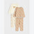 A three-piece children's pajama set laid flat on a light gray background. The set includes a cream long-sleeve top with a brown bear graphic and matching cream patterned pants, a beige long-sleeve top with an orange fox print, and matching beige patterned pants.