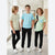 Three boys standing in a bright hallway wearing matching casual outfits. Each boy wears a short-sleeve striped T-shirt and black jogger pants with white sneakers.