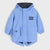 A light blue hooded raincoat with 'WOOF WOOF' printed on the chest and a small dog face detail on the front pocket, shown against a light gray background.
