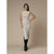 A woman modeling a sleeveless, high-neck, bodycon midi dress in a light beige or cream color, paired with black knee-high boots, against a solid beige studio backdrop.