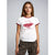 A woman modeling a white ringer t-shirt with red trim and a red graphic of a classic car and the text 'THE CLASSICS THE IMPERIAL DRIVING MACHINE' against a light gray studio background.