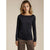 A woman modeling a black long-sleeve boat-neck top against a plain beige studio background.