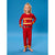 A young girl stands barefoot against a solid blue studio background, wearing a red two-piece pajama set styled like a firefighter uniform with yellow and white stripes, a yellow helmet graphic, and a black belt detail.