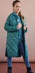 Person wearing a teal quilted coat against a pink background