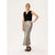 A woman modeling a sleeveless black wrap-style vest paired with a floor-length metallic silver skirt and black strappy sandals, photographed against a plain light studio background.