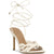 An off-white leather high-heeled sandal with intricate cutout detailing on the toe strap and ankle lace-up closure, shown against a plain white background.