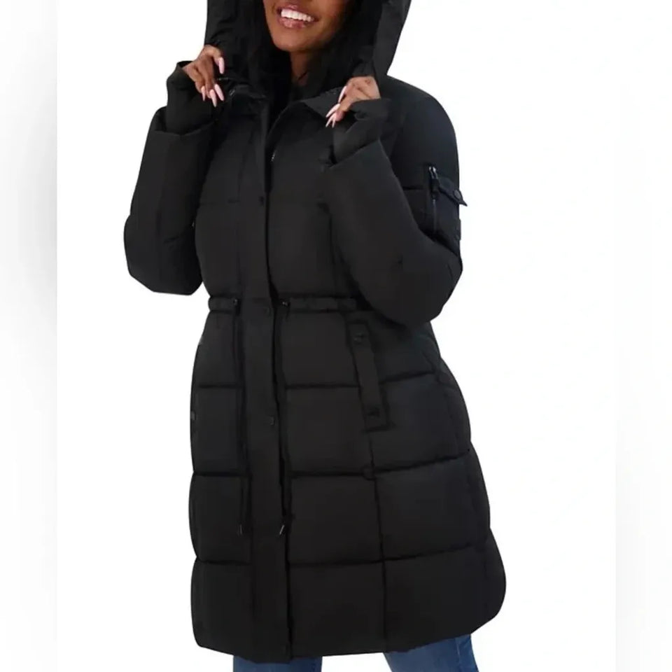 A woman wearing a black hooded puffer coat with a front zipper, horizontal quilted padding, a zippered chest pocket, and a belt detail, shown against a plain white background.