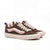 A pair of Vans low-top sneakers in dark brown suede with light pink side stripes, matching pink laces, and cream-colored soles, shown against a plain white background.