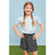 A young girl with blonde braids stands with hands on hips, wearing a light blue short-sleeve top with eyelet puff sleeves and a black floral mini skirt, set against a light blue background with green grass at the bottom.