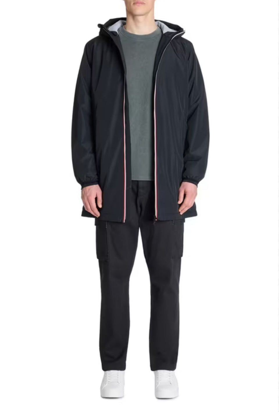 Person wearing a black hooded jacket and pants on a white background