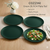 Set of four green plates with a salad on a wooden table, featuring the brand 'Cozzini'.