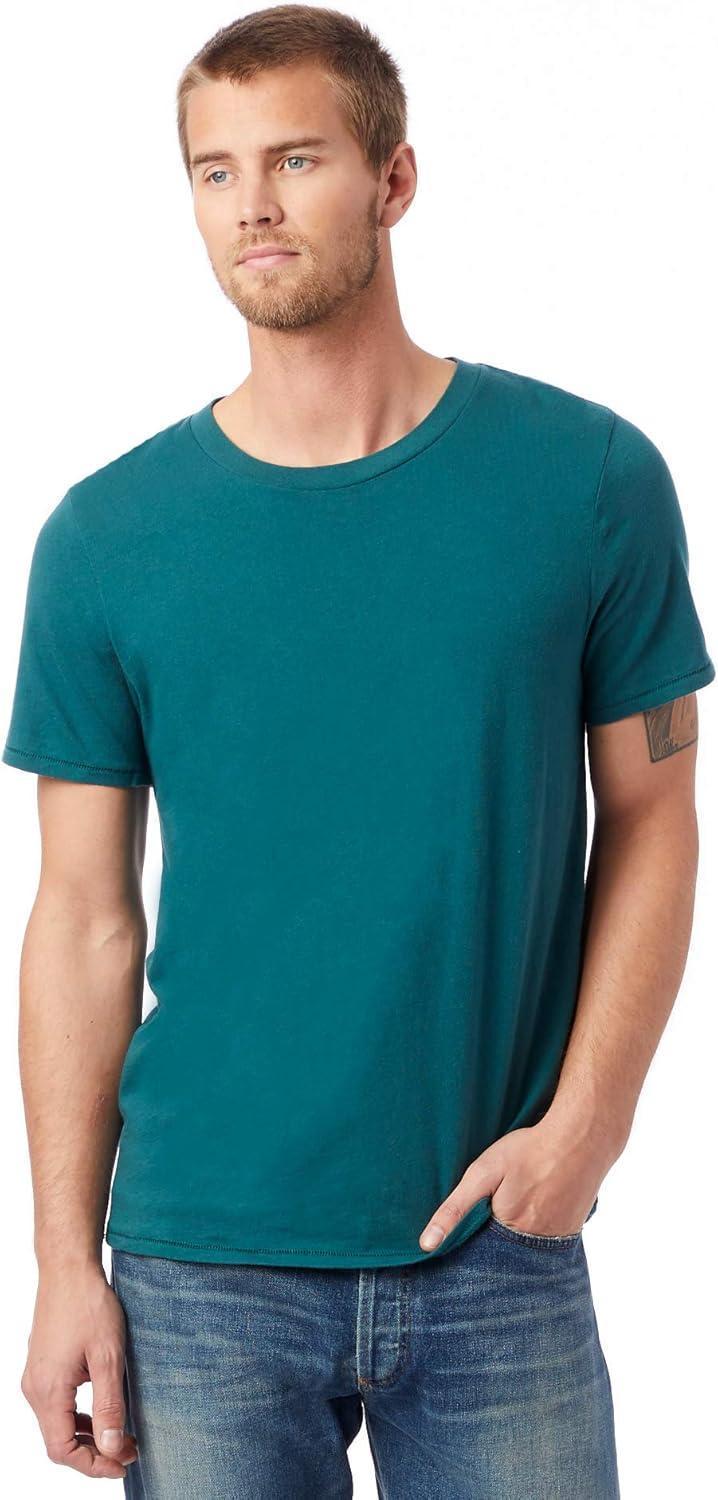 Man wearing a teal t-shirt and jeans on a white background