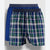 Two pairs of men's boxer briefs displayed together against a light gray background. The front pair features a blue, green, and white plaid pattern with a dark navy waistband, and the pair behind it is a solid royal blue with a matching dark navy waistband.