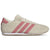 A classic low-top sneaker in beige suede and mesh with three pink stripes, a pink heel tab, and a white midsole.