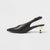 A single black leather pointed-toe slingback mule with a low kitten heel and a contrasting gold-toned metal accent on the heel, shown in profile against a light gray background.