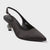 Black pointed-toe slingback pump with embellished heel on a light gray background