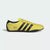 Yellow Adidas sneaker with black stripes on a white background