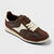 A brown and cream low-top sneaker with matching brown laces, shown from a three-quarters angle on a light gray background.