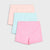 Three pairs of children's shorts in pastel colors, including light pink, mint green, and peach, arranged in a stacked fan layout on a light gray background.