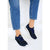 A person wearing navy blue athletic sneakers with white soles and blue jeans, shown from the calves down against a clean white background.