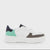 A low-top platform sneaker in white, mint green, and dark brown, featuring a chunky white sole and a dark navy heel tab, shown against a plain light gray background.
