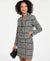 Woman wearing a black and white checkered blazer dress on a white background