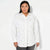 A woman modeling a white long-sleeve button-up shirt with smal silver stud embellishmentsl , paired with dark gray pants, against a plain white studio background.