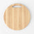 A round light wood cutting board with a built-in handle cutout at the top, shown on a clean white background.