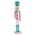 A decorative nutcracker figurine standing on a pink base, with a glittery turquoise hat, pink and white jacket, white pants, and turquoise boots, photographed on a plain white background.