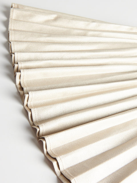 Close-up of pleated beige fabric on a light gray background