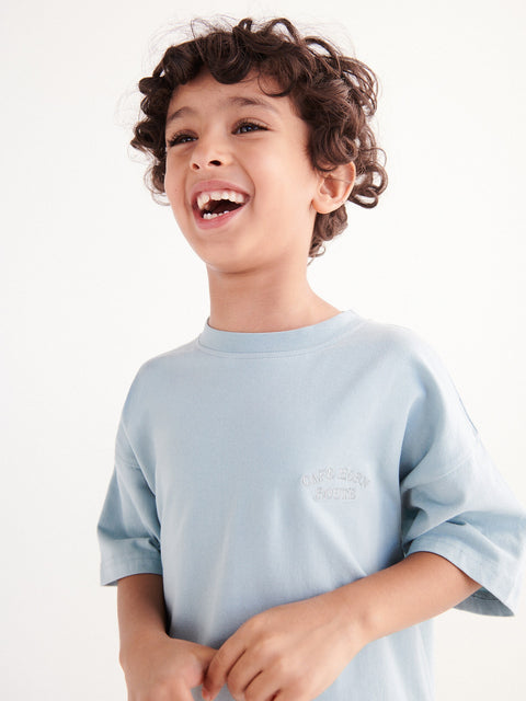 Child wearing a light blue shirt against a white background