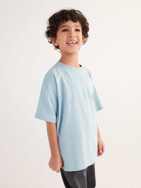 Child wearing a light blue t-shirt on a plain background