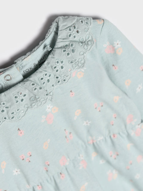 Light blue blouse with floral pattern and lace collar on a white background