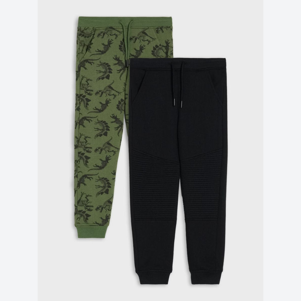 Two pairs of jogger sweatpants laid flat on a light gray background: one pair is olive green with a dark botanical print and the other is solid black with ribbed knee panels.