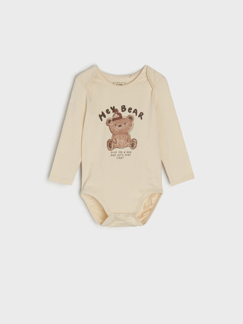 Beige baby bodysuit with teddy bear graphic and text on a white background