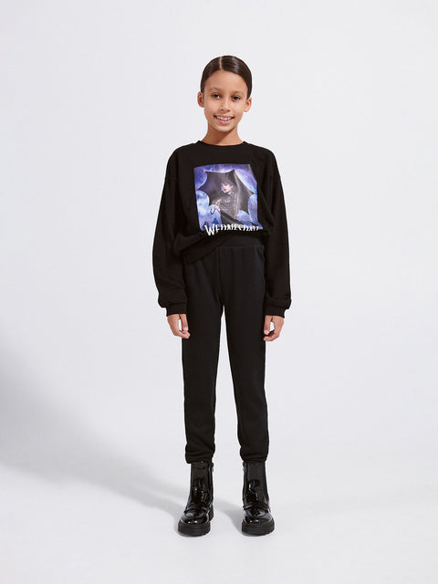 Child wearing a black outfit with a graphic design on a white background
