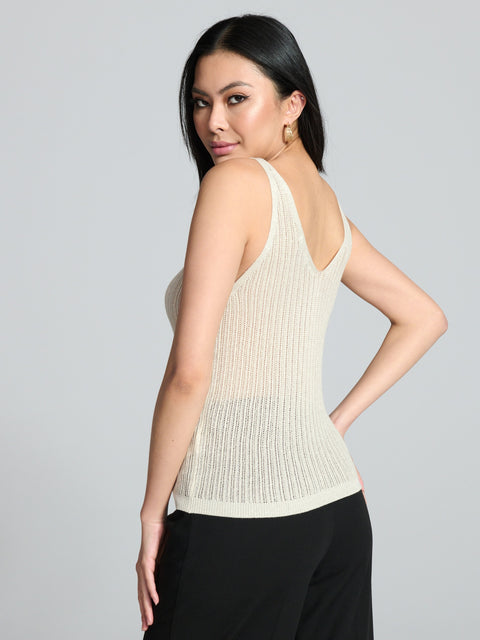 Woman wearing a beige sleeveless top against a gray background